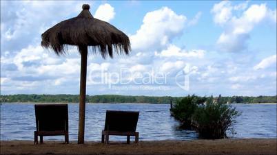 Deck chairs and umbrella at lake