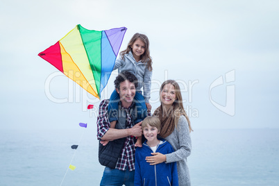 Cheerful family with kite at sea shore