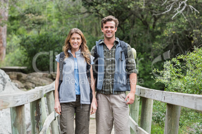 Portrait of smiling hikers on footbridge
