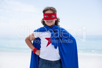 Portrait of boy in superhero costume at beach