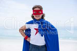 Portrait of boy in superhero costume at beach