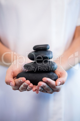 Masseuse holding stones massage