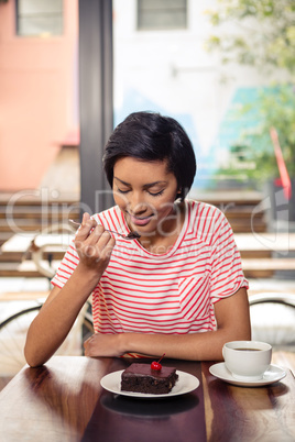 Smiling woman eating a chocolate cake