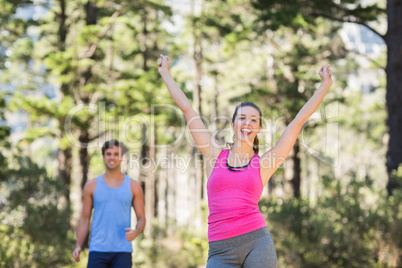 Happy woman standing with arms raised