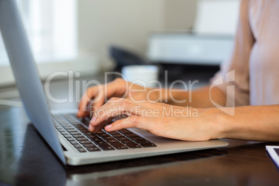 Cropped image of woman working on laptop