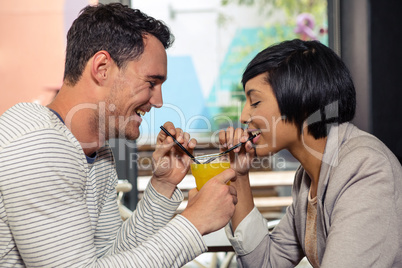 Cute couple drinking together orange juice