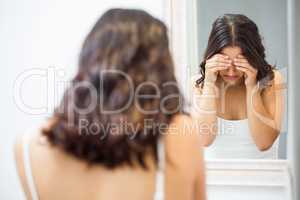 Unhappy woman standing in bathroom
