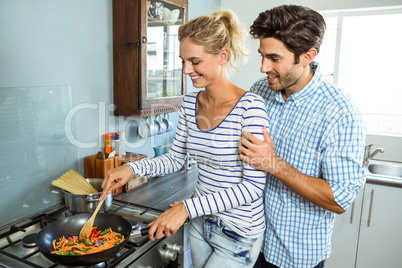 Young couple preparing food together in kitchen