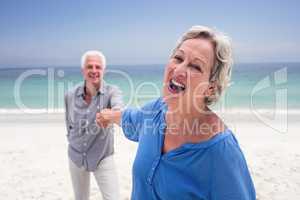 Happy senior couple holding hand on the beach