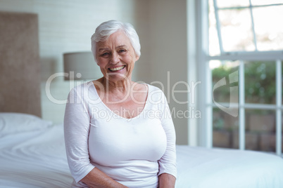 Portrait of confident senior woman on bed