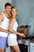 Romantic young couple cooking food in kitchen at home