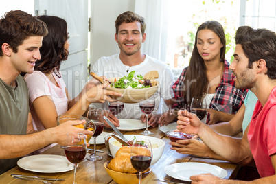 Happy friends having lunch at table