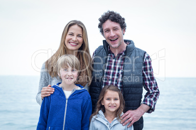 Cheerful family standing at sea shore