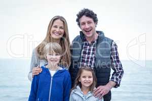 Cheerful family standing at sea shore
