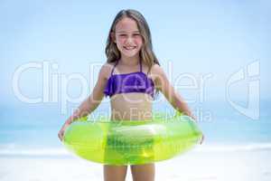 Cheerful girl with inflatable ring sea shore