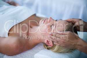 Woman receiving head massage from masseur