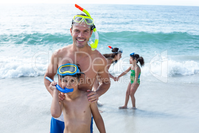 Family wearing diving goggles standing at beach