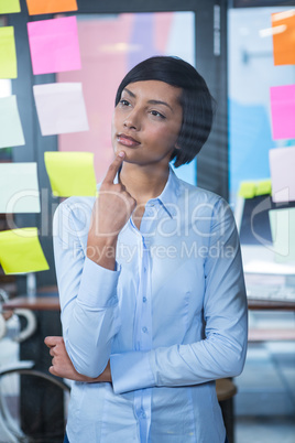 Thoughtful woman looking at sticky note