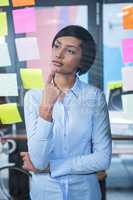 Thoughtful woman looking at sticky note