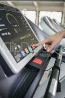 Woman touching the console display of treadmill
