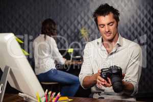 Creative businessman looking at picture on camera