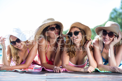 Group of happy friends lying near pool