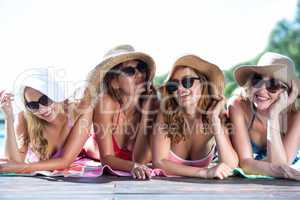 Group of happy friends lying near pool