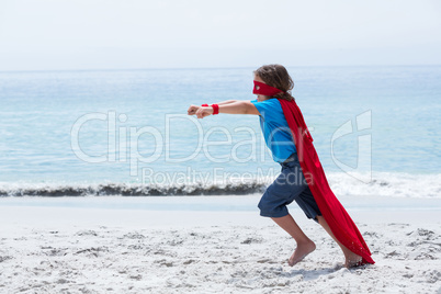 Boy in superhero costume running with clenched fist