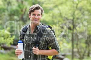 Young man holding energy drink in forest