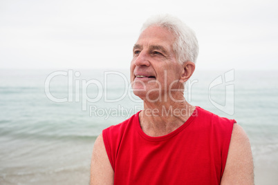Thoughtful senior man looking away on beach
