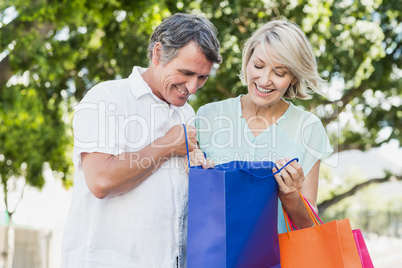 Happy couple looking in shopping bag Happy couple looking in shopping bag