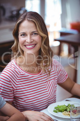 Smiling woman sitting at dining table