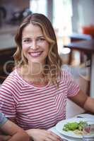 Smiling woman sitting at dining table