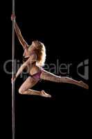 Athletic young woman show pole dance element