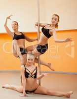 Group of young women posing in pole dance