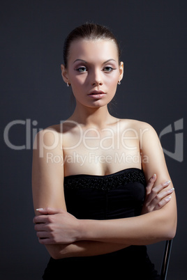 Charming slim model posing in black cocktail dress