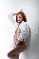 Sensual red-haired model posing nude in blouse