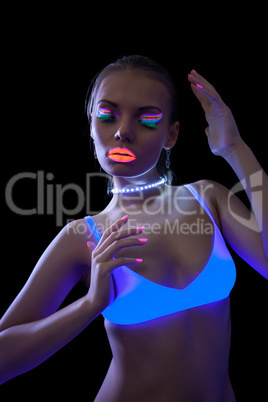Pretty slim girl dancing under fluorescent light
