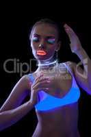 Pretty slim girl dancing under fluorescent light