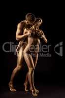 Sensual nude man and woman posing as golden statue