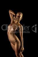 Sensual woman with golden skin posing as statue