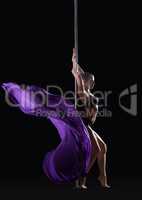 Young slim pole dancer posing with violet cloth