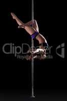 Athletic young pole dancer, isolated on black