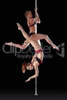 Two athletic young girls dancing on pilon