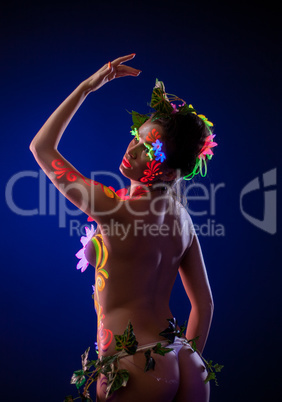 Sensual woman posing with uv glowing flowers