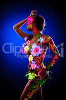 Sexy model posing with glowing flowers - uv light