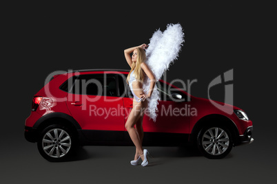 Cute blonde in angel costume standing near red car