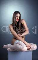 Beautiful smiling nude model posing in stockings