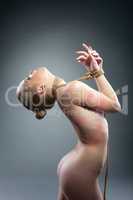 Naked girl with rope around her neck and hands
