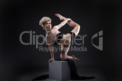 Studio shot of graceful slim model dancing on cube